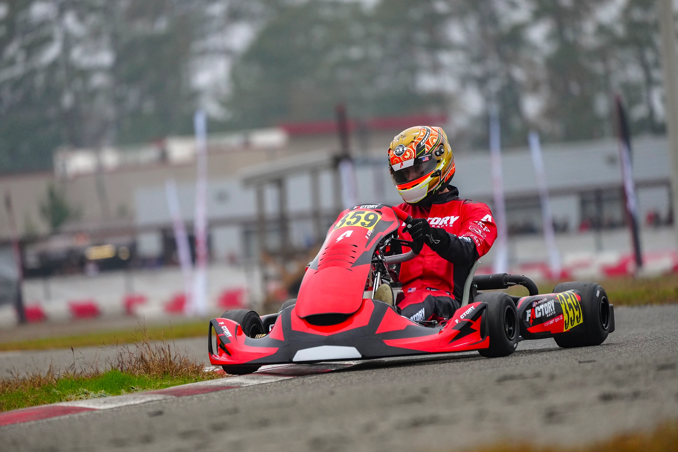 A red Factory Karts chassis at speed on track